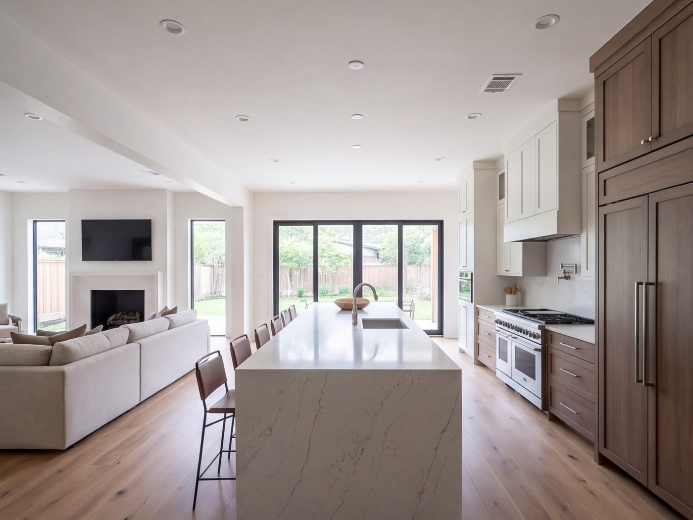 Wide galley-turned-open kitchen with a long island beside a family room